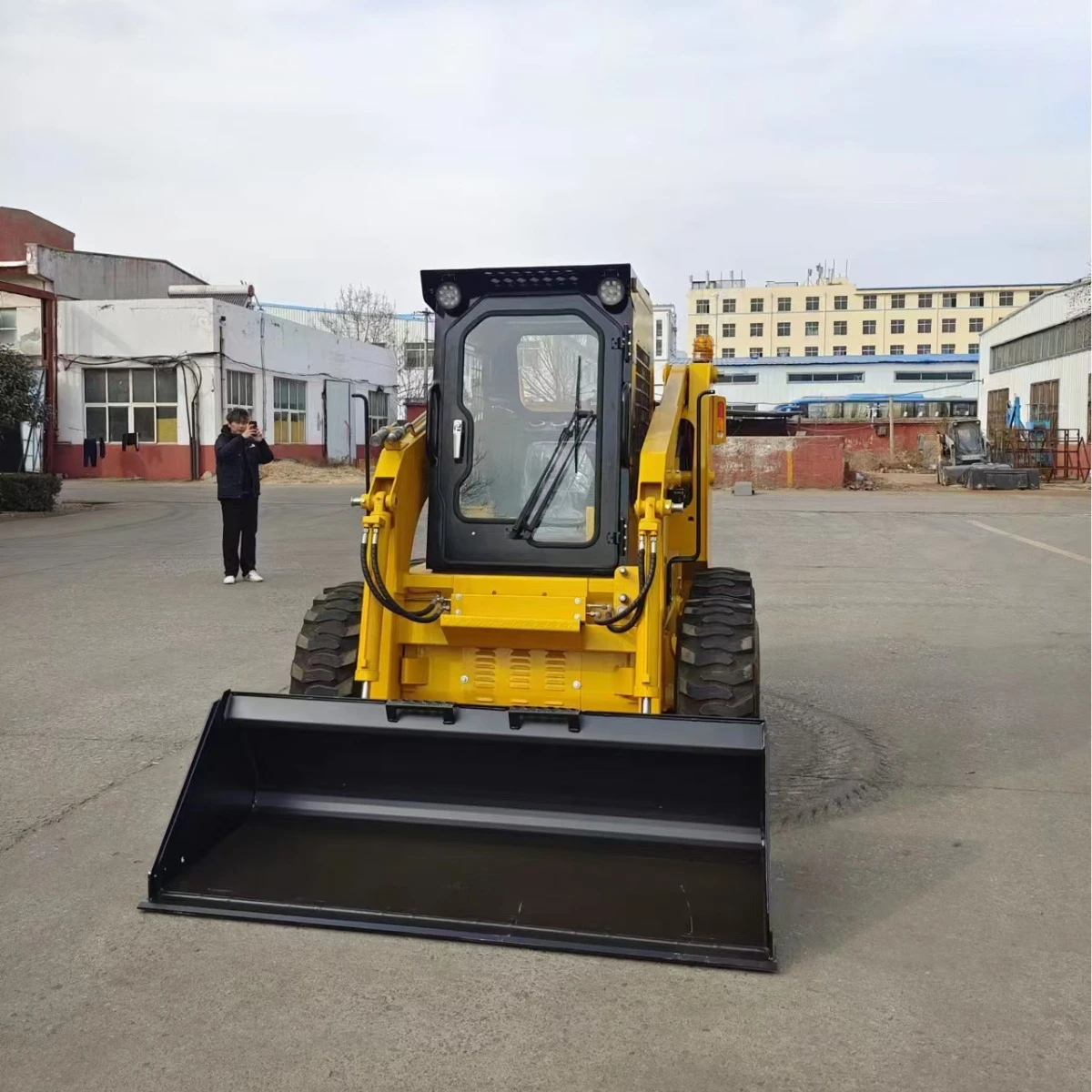 Небольшой мини-погрузчик с бортовым поворотом на строительной площадке - Фотография_3